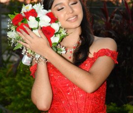 Quinceañera con vestido rojo y ramo de flores