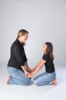 Retrato de dos personas sentadas frente a frente en estudio