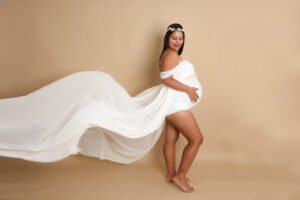 Retrato de maternidad con tela blanca en movimiento