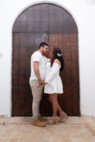 Pareja abrazada frente a una puerta de madera