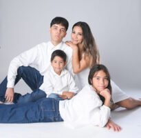 Retrato familiar en estudio con camisetas blancas y pantalones de mezclilla
