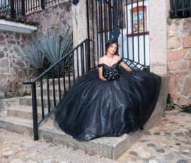 Quinceañera con vestido negro en una escalera