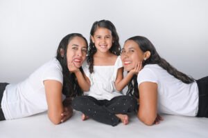 Retrato familiar de tres personas sentadas en estudio