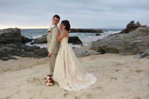 Pareja abrazada en una playa rocosa