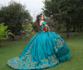 Quinceañera con vestido turquesa en un jardín