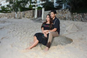 Pareja sentada sobre rocas junto al mar