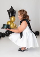 Retrato de cumpleaños con vestido blanco y globos negros