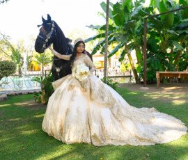 Quinceañera con vestido dorado en un jardín