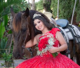 Quinceañera con ramo junto a un caballo