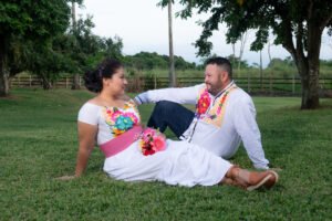 Pareja sentada en el césped con un ramo