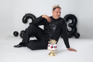 Retrato de cumpleaños con traje negro, pastel y globos