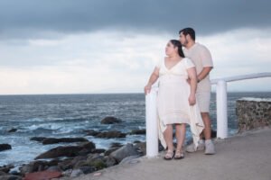 Pareja tomada de la mano junto al mar