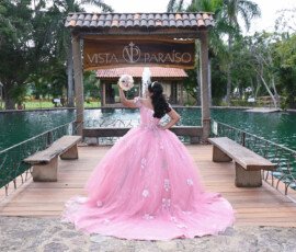 Quinceañera con vestido rosa en un puente de madera