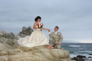 Pareja sentada sobre rocas junto al mar