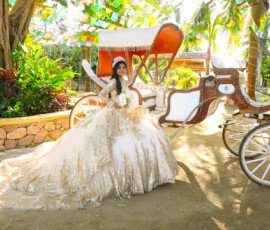 Quinceañera con vestido blanco junto a un carruaje
