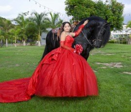 Quinceañera con vestido rojo en un jardín