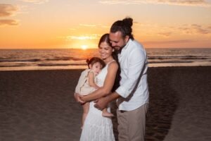 Familia abrazada en la playa al atardecer
