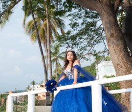 Quinceañera con vestido azul en un puente de madera