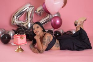 Retrato de cumpleaños recostada junto a globos rosas