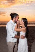 Pareja abrazada frente al mar al atardecer