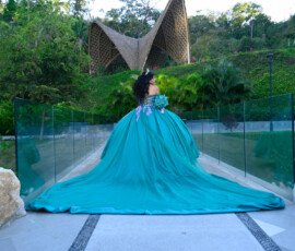 Quinceañera con vestido turquesa junto a una piscina