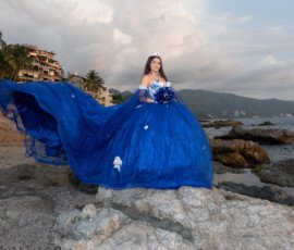 Quinceañera con vestido azul junto al mar
