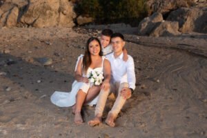 Familia sentada en una playa rocosa