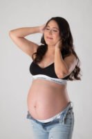 Retrato de maternidad en estudio con las manos sobre el vientre