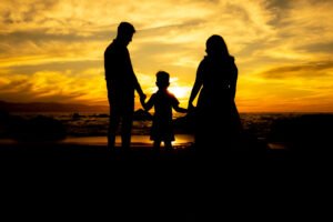 Silueta de una familia tomada de la mano al atardecer
