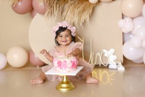 Bebé con un pastel y decoración de primer cumpleaños