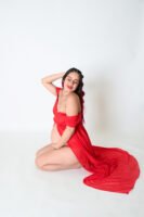 Retrato de maternidad con vestido rojo en estudio