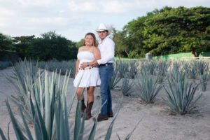 Pareja abrazada en un sendero rodeado de vegetación