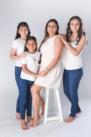 Retrato familiar en estudio con camisetas blancas y pantalones de mezclilla