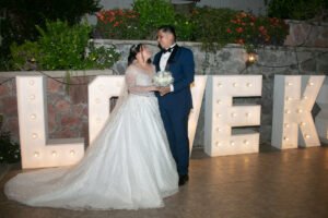 Novios junto a letras decorativas de boda