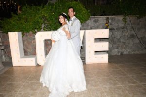 Novios junto a letras decorativas de boda