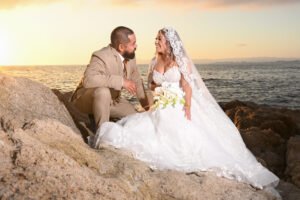 Novios sentados sobre las rocas al atardecer