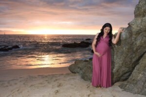 Retrato de maternidad con vestido morado junto al mar