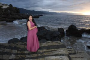 Retrato de maternidad con vestido morado junto al mar