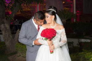 Primer plano de novios abrazados con su ramo