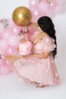 Retrato de cumpleaños con vestido rosa y globos