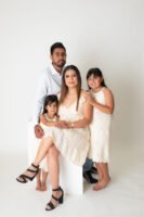 Retrato familiar con vestidos blancos en estudio
