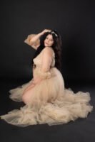 Retrato de maternidad con vestido de tul sobre fondo beige