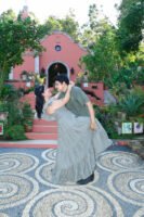 Pareja bailando frente a una fachada con vegetación