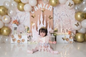 Retrato infantil con vestido claro y globos blancos y dorados
