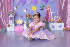 Retrato infantil con vestido lila y decoración de princesas