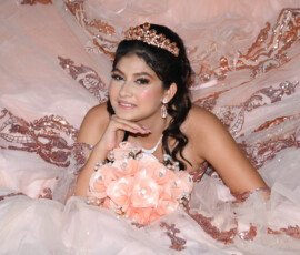 Retrato de quinceañera con corona sobre fondo rosa