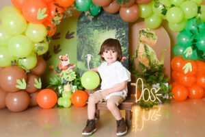 Retrato infantil con globos verdes y naranjas