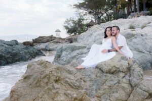 Pareja abrazada en una playa rocosa