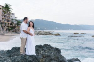 Pareja abrazada en una playa rocosa