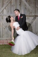 Novios sentados juntos con un ramo de rosas rojas